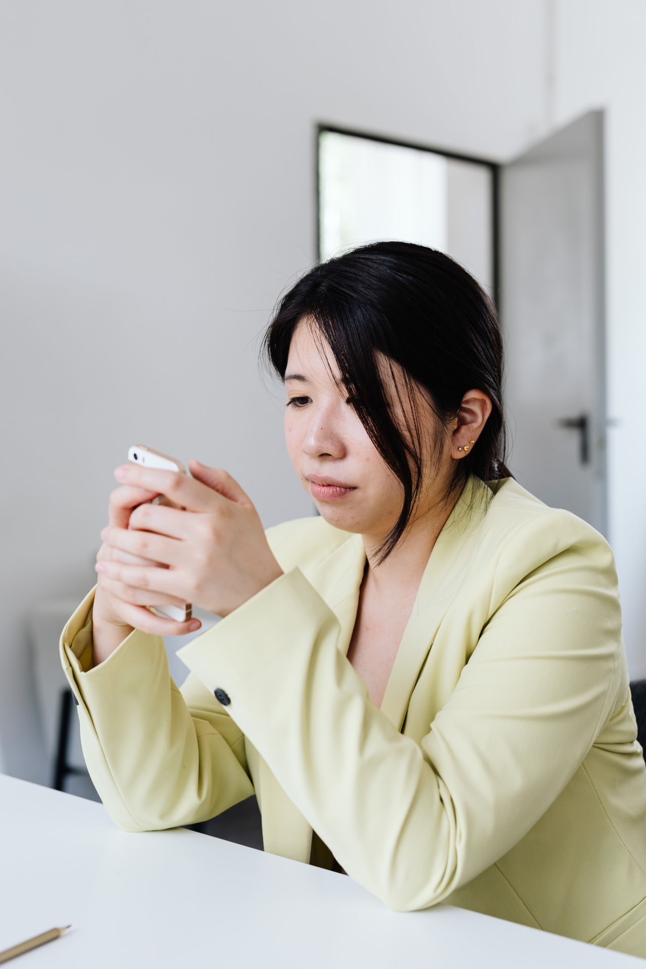 Mulher olhando o celular com cara de dúvida